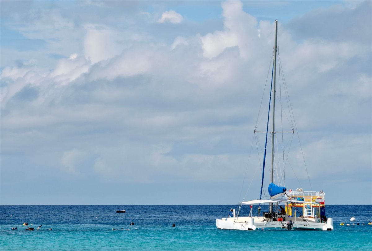 A sailing catamaran anchored in turquoise Caribbean water off Barbados